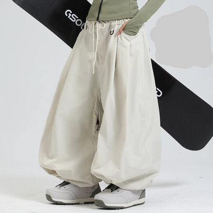 Beige pants worn by a person with a black snowboard in the background