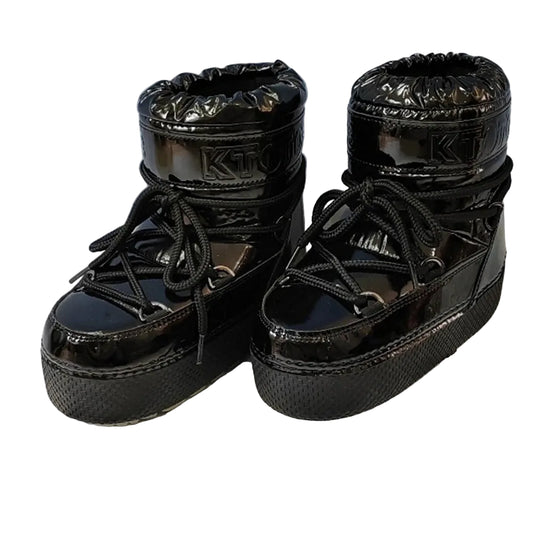 Black platform boots on a wooden block with a white background
