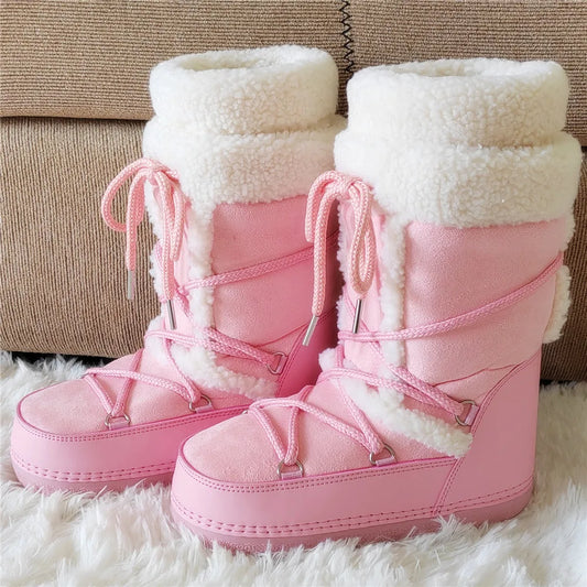 Pink snow boots with white fur lining on a fluffy white surface.