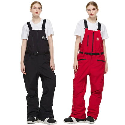 Two people wearing black and red bib overalls on a white background