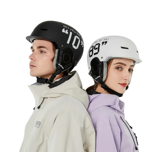 Two people wearing ski helmets  on a plain background