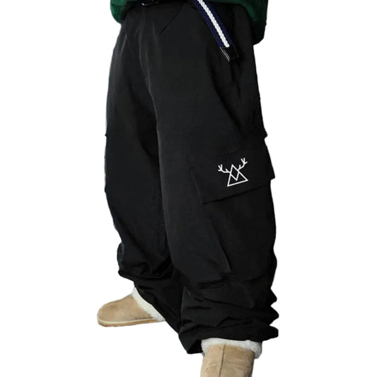 Person wearing a black outfit with a white logo in the snow