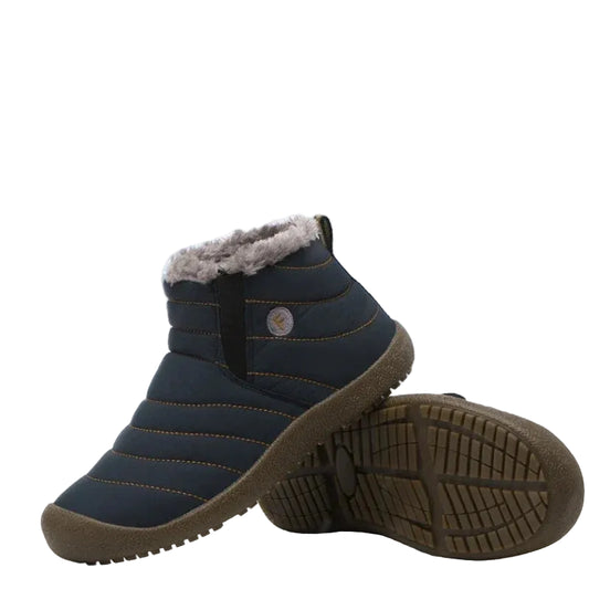 Pair of winter boots with fur lining on a snowy background